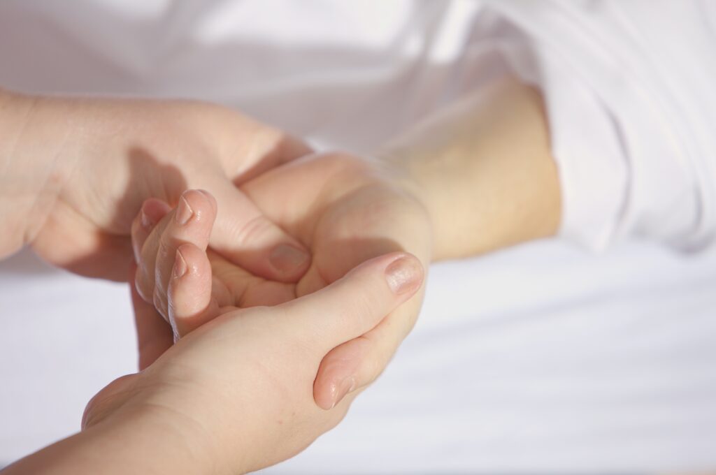 Masseur geeft een klant die chemo heeft gehad een handmassage