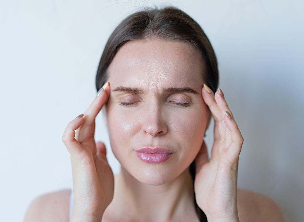 Vrouw met migraine heeft handen op haar hoofd